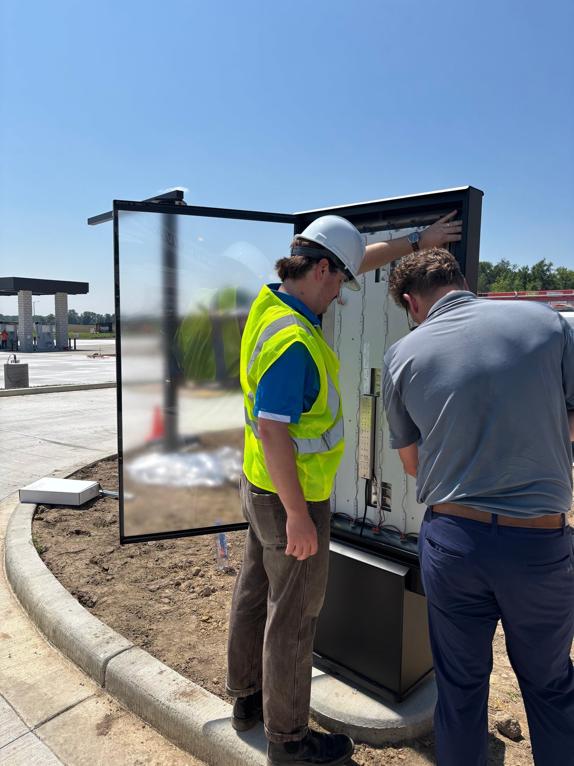 Howard Company technician installing an outdoor drive-thru menu board Howard Company technician installing an outdoor drive-thru menu board