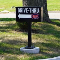 Branded directional signs point guests to the drive-thru lane.