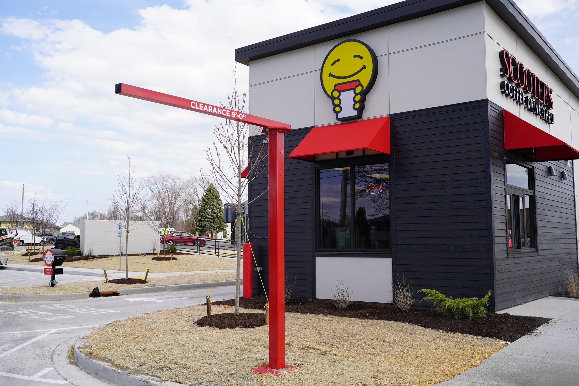 Scooter's Coffee drive-thru clearance bar with red powder-coated structural steel pole, installed by The Howard Company